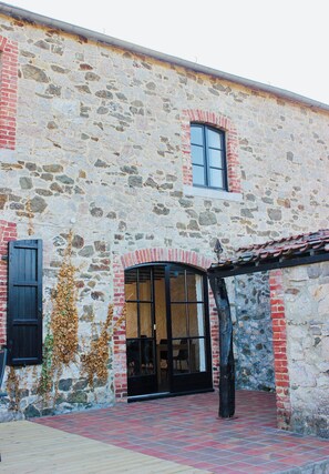 A stone building with a tiled entrance and a wooden door. - Charming vacation home with a terrace and garden (Sart-en-Fagne)
