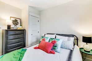 A neatly arranged bedroom with a bed, a dresser, a nightstand, and a lamp. - The Pine House: Unit A near 6th Ave, UPS, UW, and Point Ruston (Tacoma)