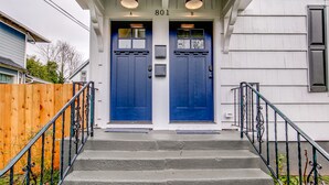 A two-door entrance with a wooden fence and metal railings.