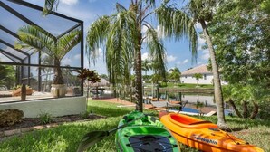 A glass-enclosed area with kayaks and a pool.
