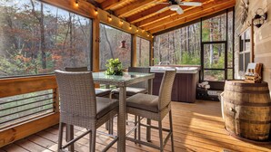 A wooden deck with a table and chairs, a ceiling fan, and a view of the forest. - Cozy Blue Ridge Escape •Hot Tub•Fireplace-2 acres with covered porch/Fireplace (Mineral Bluff)