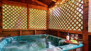 A hot tub with a wooden deck and a wooden lattice wall. - Rustic Escape: Nature Views, Hot Tub & Fire Pit (Sevierville)
