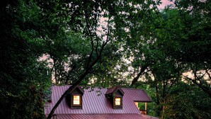 A rustic cabin with a metal roof, a front porch, and a pathway leading to the entrance. - Rustic Escape: Nature Views, Hot Tub & Fire Pit (Sevierville)