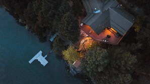 Luftaufnahme eines Hauses mit einem sichtbaren Steg und einer Wendeltreppe, die zur oberen Ebene führt.