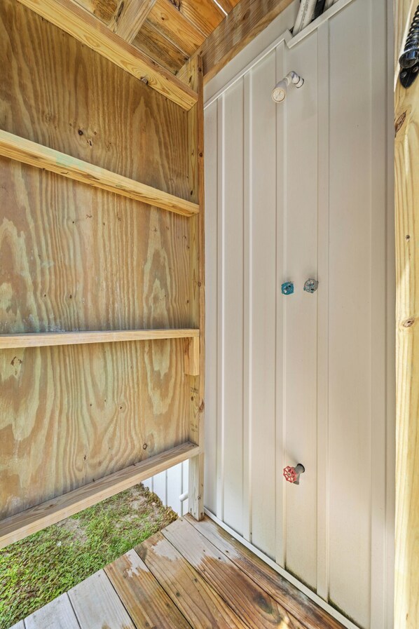 A wooden exterior wall with a white door and two small windows.