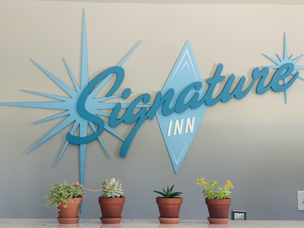 A wall with a large sign that reads "Signature Inn".