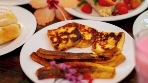 A table with various food items including pancakes, waffles, and fruit. - Pousada Beach Garden (Ipojuca)