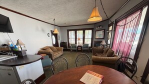 A compact living space with a kitchenette, dining table, and two sofas. - Historic Home | Walk to Lake & Strip Fun (Geneva)