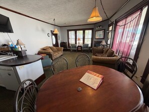 A compact living space with a kitchenette, dining table, and two sofas.