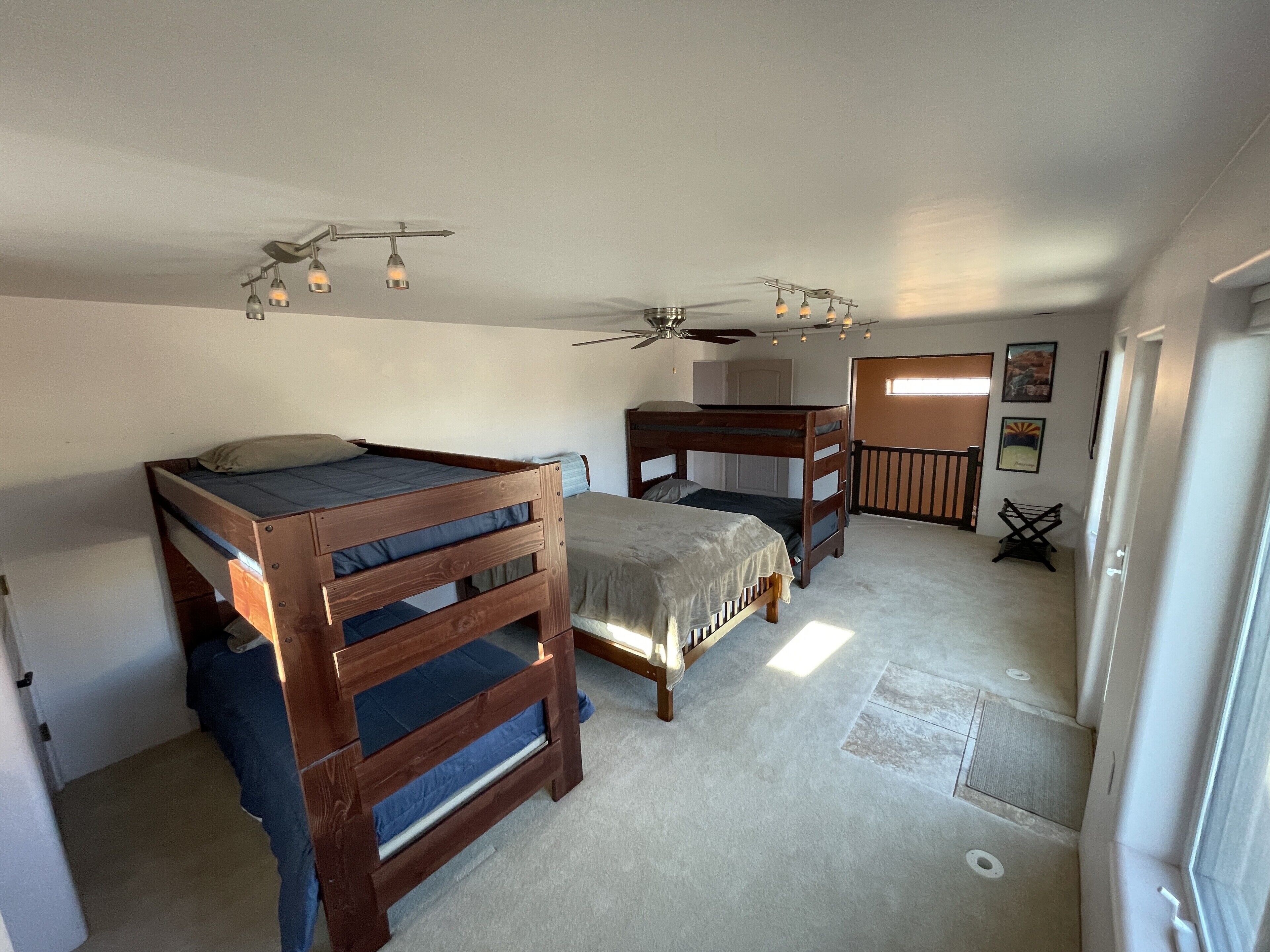 Ein Schlafzimmer mit zwei Etagenbetten, einem Deckenventilator und einem Fenster mit Blick.