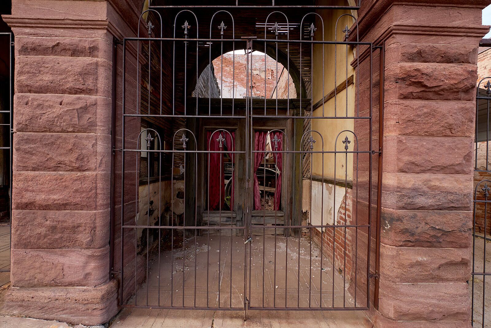 A gated entrance with a brick archway and a metal gate.