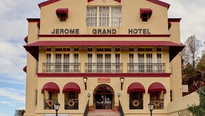The Jerome Grand Hotel with a prominent entrance, a second-story balcony, and a sign for the Asylum restaurant.