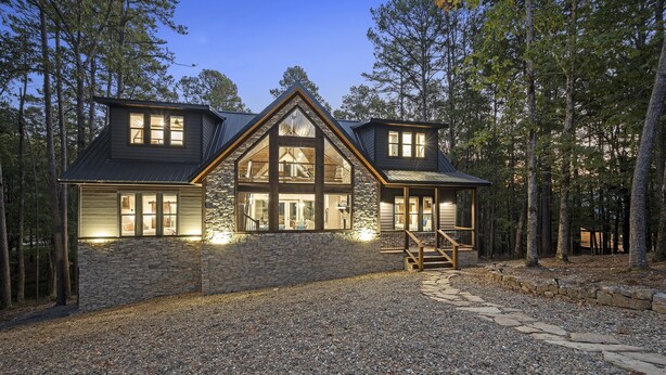 A large, two-story log cabin with a stone foundation and a prominent gable roof, surrounded by a forested area. - Lux Cabin Private Pond Cust Playset 1 Mile to Lake Cvrd Deck+Entmt Amenities (Broken Bow)