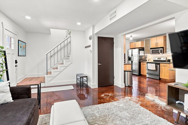 A modern interior with a staircase, a kitchen, and a living area.