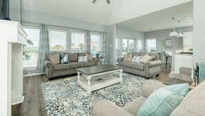 A spacious living room with two sofas, a coffee table, and a patterned rug.