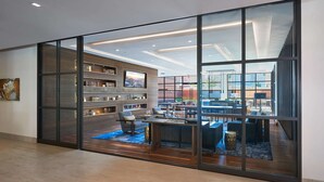 A modern interior with a large sliding glass door leading to a dining area with multiple tables and chairs. - Global Luxury Suites Clarendon Metro (Arlington)