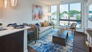 A modern living room with a sofa, coffee table, and dining area. - Global Luxury Suites Clarendon Metro (Arlington)