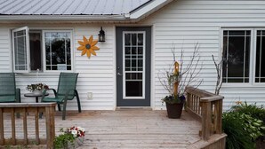 Ein Haus mit einer Veranda, einer Blumenwand und einem Topfpflanzen.