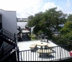 Enjoy a serene outdoor space with a circular seating area, staircase, and breathtaking views of the surrounding water.