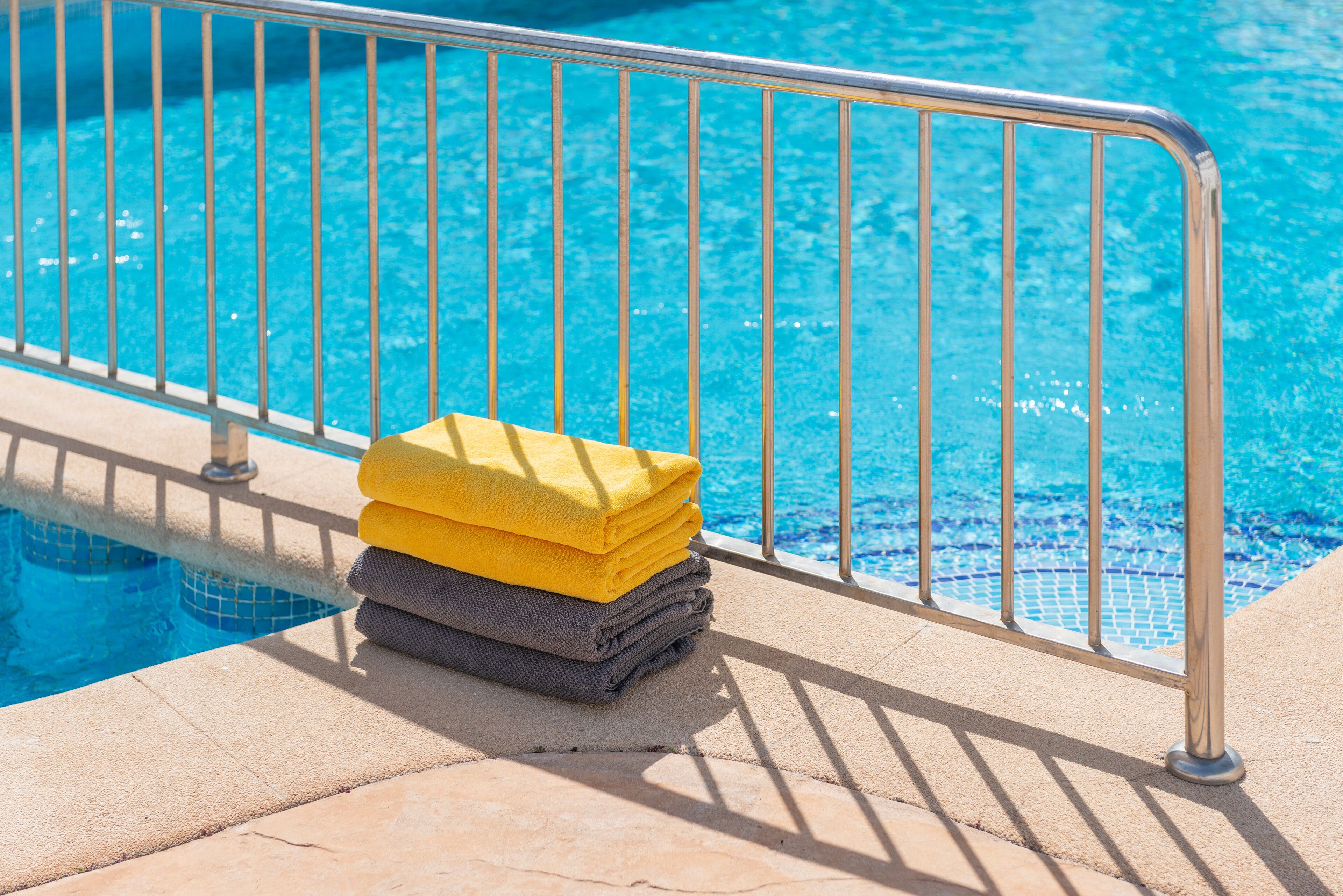 Una piscina al aire libre, sillones reclinables de piscina
