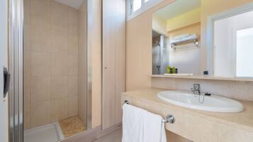 Ein modernes Badezimmer mit Dusche, Waschbecken und Spiegel.