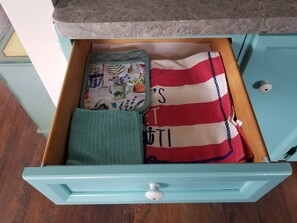 A drawer with a green towel, a red and white striped cloth, and a patterned cloth with gardening tools. - Open concept 2 bedroom ranch with attached garage and deck (Essexville)