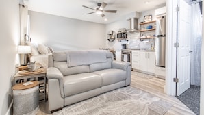 A modern kitchen with stainless steel appliances, a ceiling fan, and a 'No Wake Zone' sign.