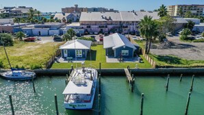 A marina with a boat docked, a small boat, and a building with a sloped roof.