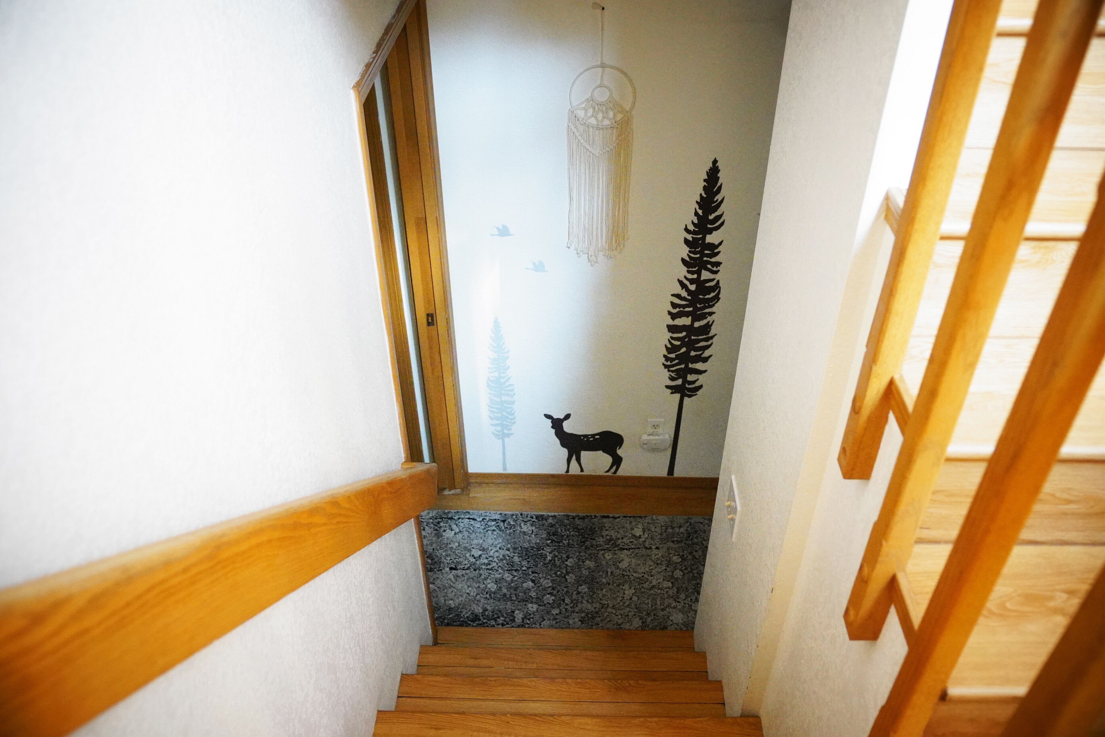 Una escalera estrecha con barandillas de madera y un escalón de piedra.