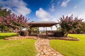 A gazebo with a stone pathway leading to it, surrounded by well-maintained grass and flowering trees. - Hot Springs Home with a View 1 Bedroom Sleeps 4 (Hot Springs)