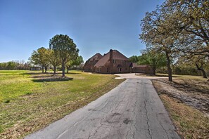 A large brick house with a driveway leading to the entrance. - 16-Acre Pilot Point Ranch: Private Pond (Pilot Point)