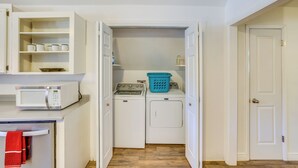 A laundry area with a washing machine, dryer, and a microwave.