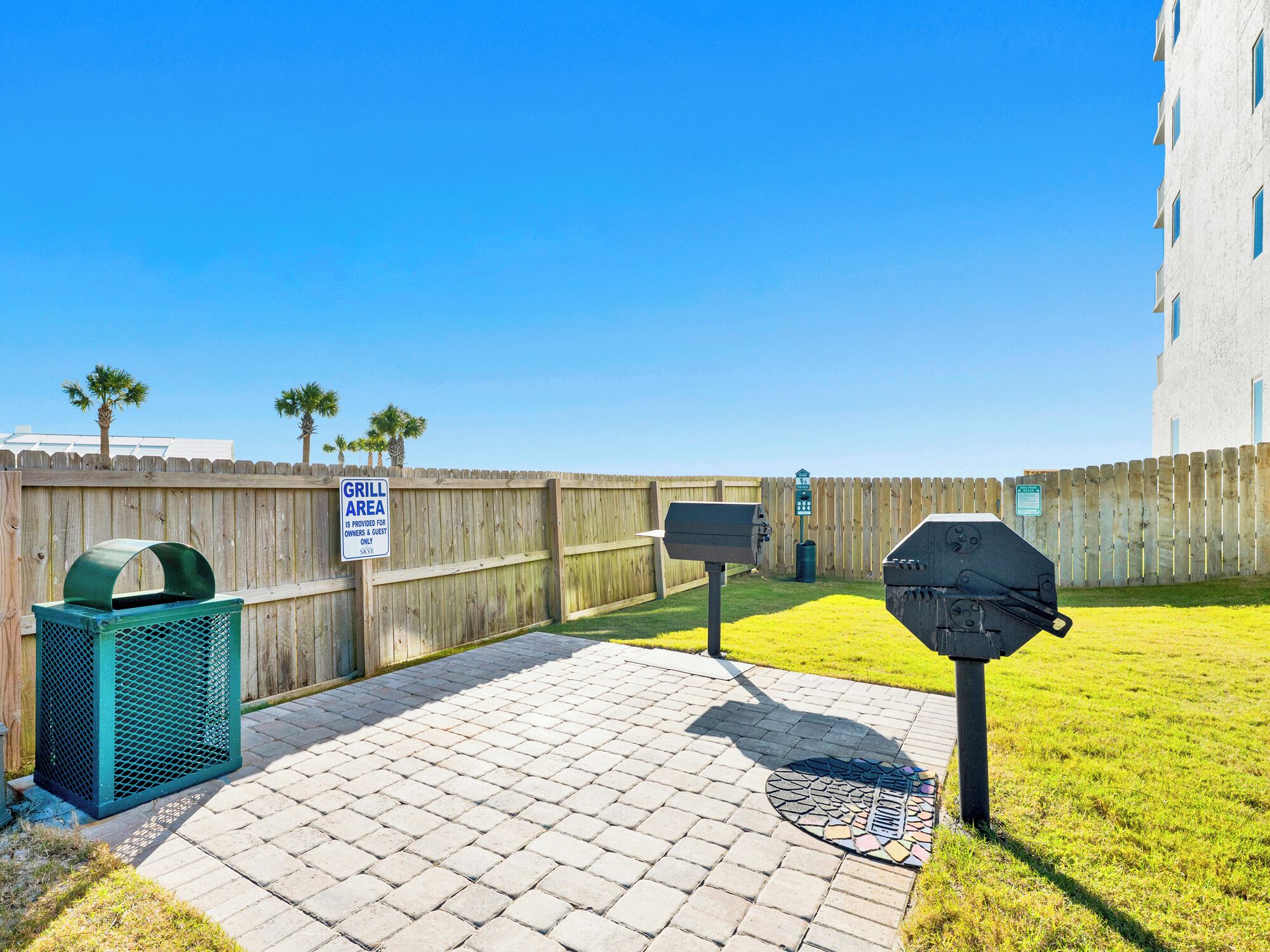 A patio area with a grill, a trash can, and a mailbox.