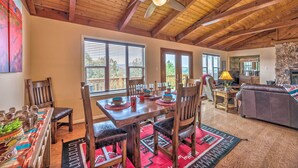 A spacious living room with a wooden ceiling, a dining area with a wooden table and chairs, and a cozy seating area with a couch. - Alto Cabin w/ Stunning Views, Hot Tub + Sauna! (Alto)