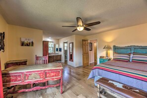 A bedroom with a bed, a desk, a chair, a ceiling fan, and a door leading to another room. - Alto Cabin w/ Stunning Views, Hot Tub + Sauna! (Alto)