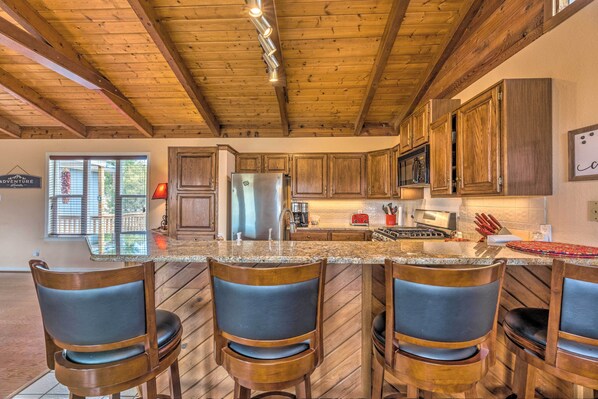 Enjoy cooking in this well-equipped kitchen with a central island, stove, microwave, and refrigerator.