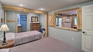 Quarto com cama, cômoda e espelho.