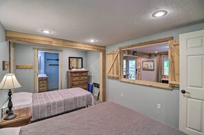 Un dormitorio con cama, cómoda y espejo.