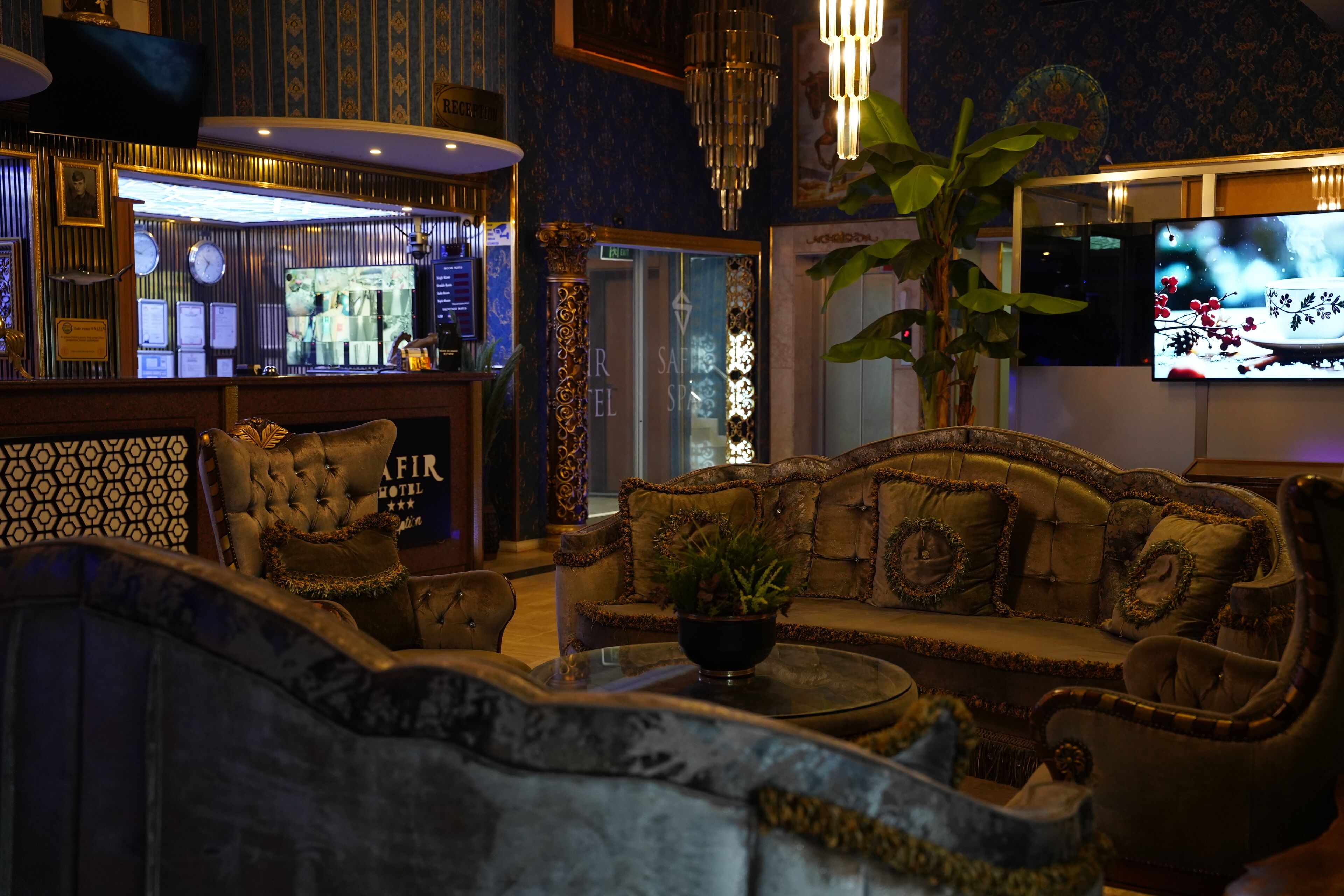 Un lobby lujoso con una zona de bar, un conjunto de sofás y una pantalla de televisión.
