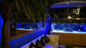 Ein Zimmer mit einem Bett, einem großen Aquarium und einem wandmontierten Spiegel.