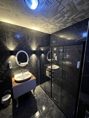 Deluxe vierpersoonskamer | Badkamer | Designer toiletartikelen, een haardroger, pantoffels, handdoeken