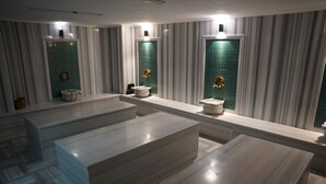 Ein modernes Badezimmer mit Marmorplatten, zwei Waschbecken und einem großen Spiegel.