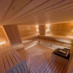 Una sauna amb seients de fusta i una unitat de calefacció central.
