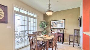 A dining area with a large table, chairs, a chandelier, a plant, and a framed picture on the wall. - 4 Mi to Bethany Beach: Sunny Escape w/ Porches! (Ocean View)