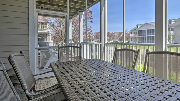 A covered patio with a table and chairs, overlooking a residential area with houses and a fence. - 4 Mi to Bethany Beach: Sunny Escape w/ Porches! (Ocean View)