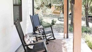 A covered patio with two rocking chairs and a hanging light fixture. - The White Barn (Julian)