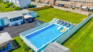 A residential area with a swimming pool, houses, and a small building with outdoor seating. - Seashell Cottages/JK Rentals - Cottage 1, 2 full beds, 1 twin (Old Orchard Beach)
