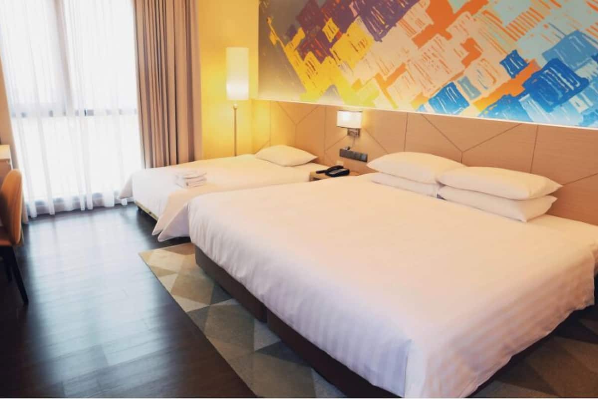 Habitación de hotel con dos camas, un ventanal con cortinas, una lámpara de pared y un cuadro abstracto de colores.