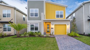 A modern two-story residential building with a yellow front door and a garage. - AS2811  Storey Lake Condo 5 bed 5 bath  Free Waterpark (Kissimmee)