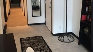 A hallway with a coat rack, a clock, and a bookshelf. - Steps from Gondola, views of Beaver Creek slopes, newly remodeled 2 BR 2BA Condo (Avon)